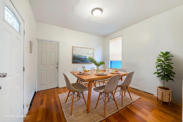 dining area featuring light wood finished floors and baseboards