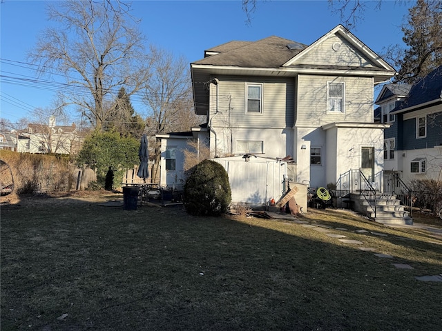 rear view of house featuring a yard