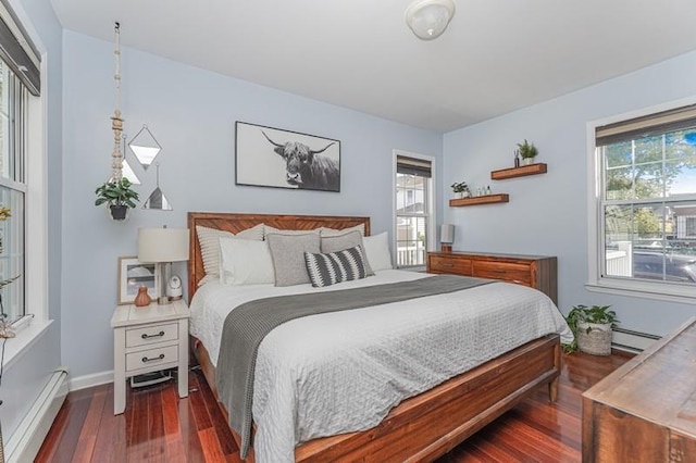 bedroom with a baseboard heating unit, multiple windows, baseboard heating, and wood finished floors