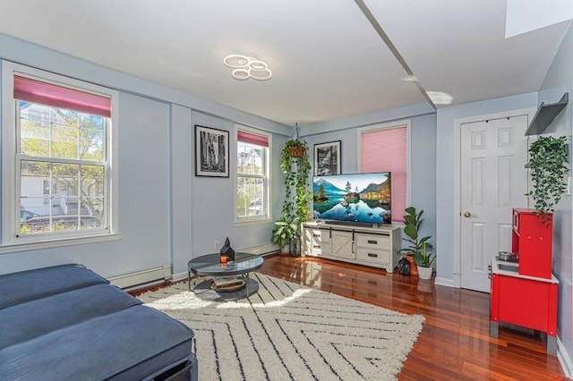 living area featuring baseboard heating, wood finished floors, and baseboards