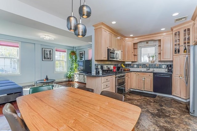 kitchen featuring decorative backsplash, dark countertops, stainless steel appliances, light brown cabinets, and a sink