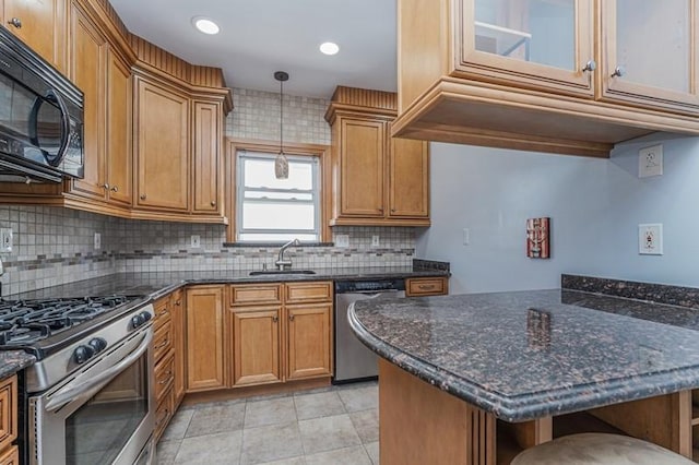 kitchen with appliances with stainless steel finishes, brown cabinets, a sink, and decorative light fixtures