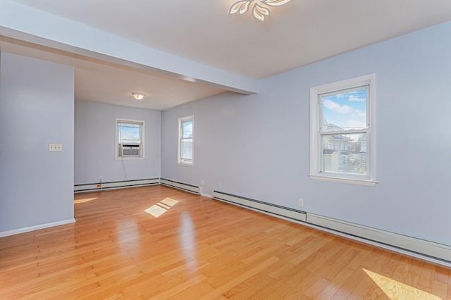 unfurnished room with a baseboard heating unit, beamed ceiling, light wood-type flooring, and baseboards