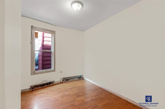 empty room featuring hardwood / wood-style flooring and baseboards