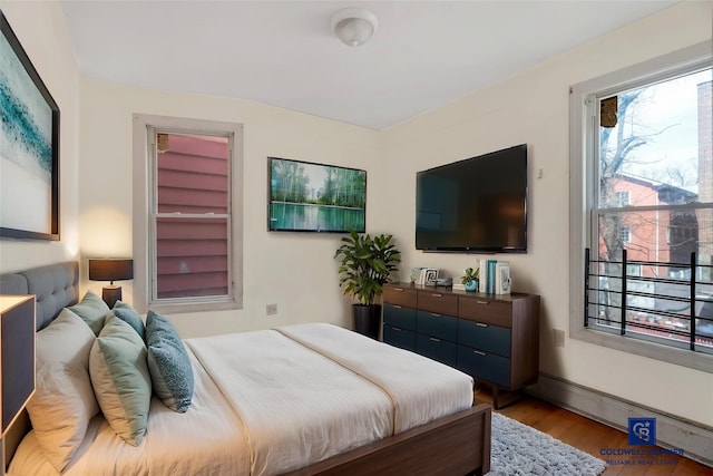 bedroom featuring baseboards and wood finished floors