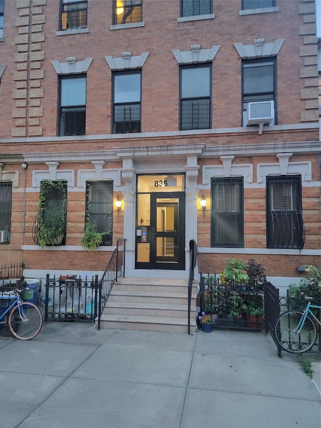 doorway to property with brick siding and cooling unit