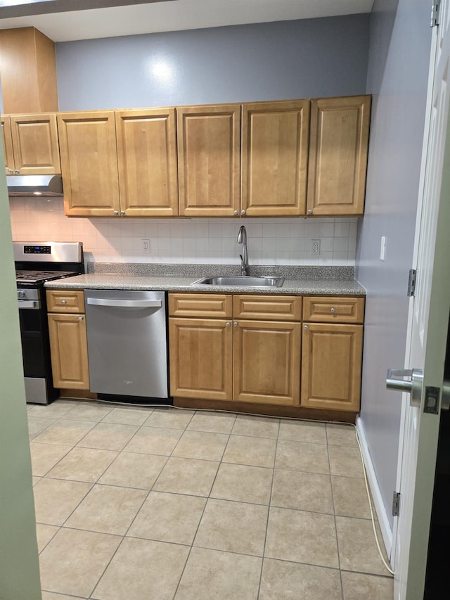 kitchen featuring light tile patterned floors, backsplash, stainless steel appliances, under cabinet range hood, and a sink