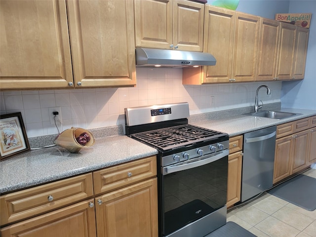 kitchen with light tile patterned floors, tasteful backsplash, stainless steel appliances, under cabinet range hood, and a sink