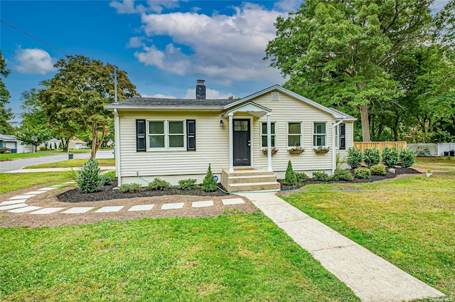 view of front of house featuring a front yard, fence, and a chimney