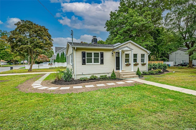 view of front of house featuring a front lawn and a chimney