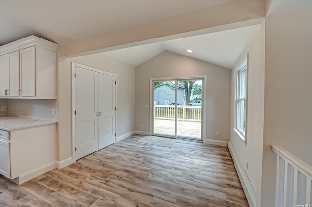 interior space featuring vaulted ceiling, light wood finished floors, recessed lighting, and baseboards