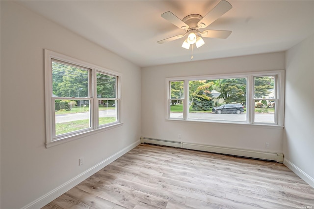 unfurnished room with a baseboard radiator, baseboards, plenty of natural light, and light wood finished floors