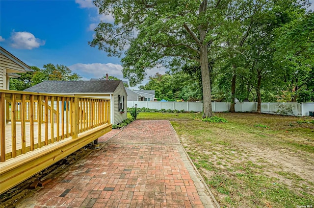 view of yard featuring a fenced backyard, a patio, and a wooden deck