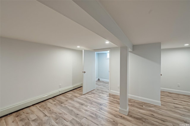 finished basement featuring a baseboard radiator, light wood-style flooring, baseboards, and recessed lighting