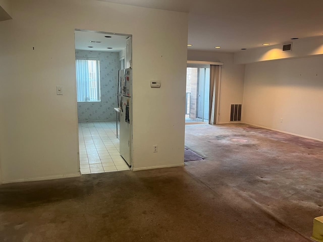 unfurnished room featuring visible vents, light carpet, and baseboards