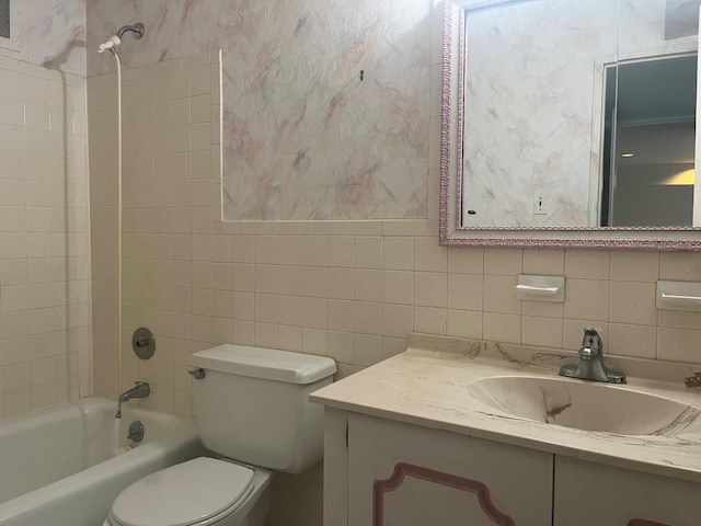 bathroom featuring tile walls, bathing tub / shower combination, backsplash, toilet, and vanity