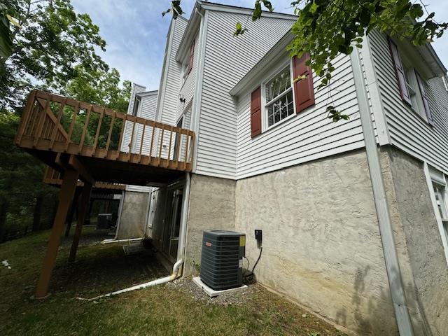 back of property featuring a deck and central AC