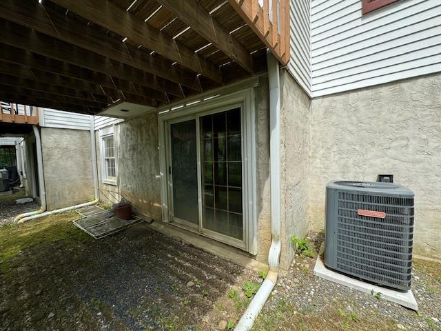 exterior space with stucco siding and central air condition unit