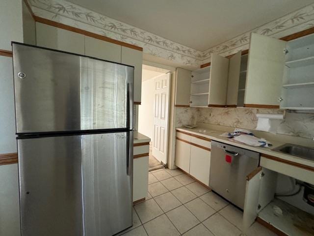 kitchen with stainless steel appliances, white cabinetry, light countertops, open shelves, and wallpapered walls