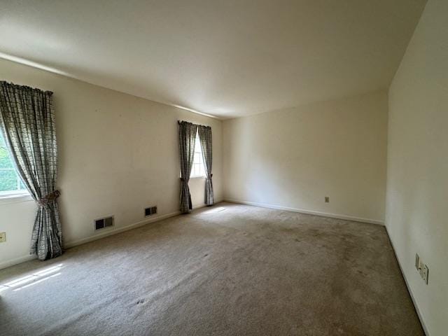 carpeted empty room with visible vents and baseboards