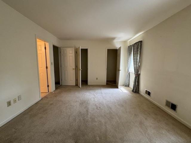 unfurnished bedroom featuring carpet floors, visible vents, and baseboards