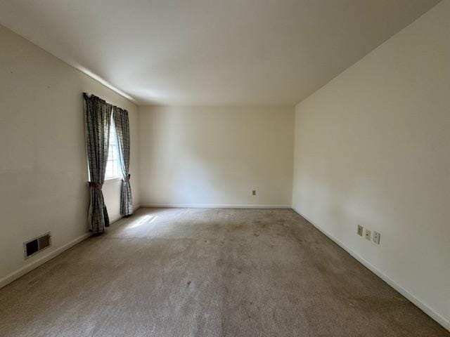 carpeted empty room featuring visible vents and baseboards