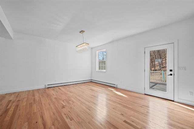 unfurnished dining area featuring light wood-type flooring, baseboards, a chandelier, and a baseboard radiator