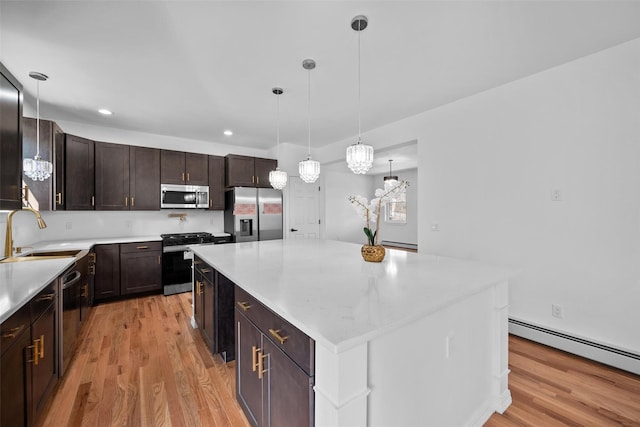 kitchen featuring light wood-style floors, stainless steel appliances, a sink, and light countertops