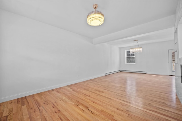 empty room featuring baseboards, baseboard heating, wood finished floors, and an inviting chandelier