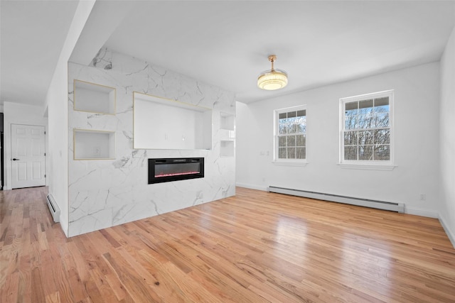 unfurnished living room with a baseboard heating unit, an AC wall unit, a fireplace, and wood finished floors