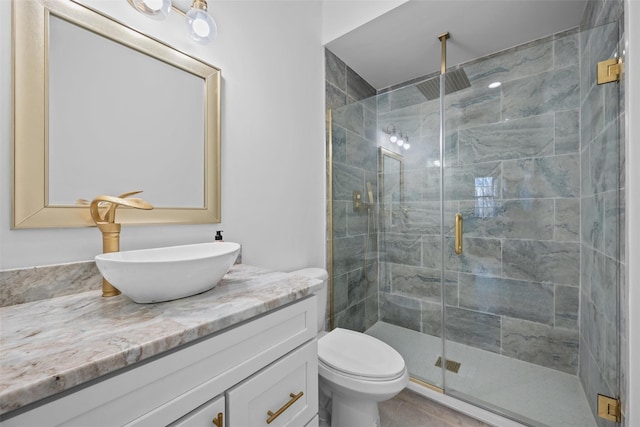 bathroom featuring a stall shower, tile patterned flooring, vanity, and toilet