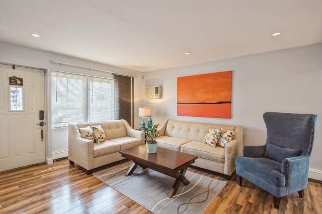 living room featuring recessed lighting, a wall mounted air conditioner, and wood finished floors