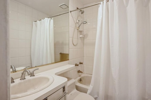 bathroom with toilet, shower / bath combo with shower curtain, and vanity