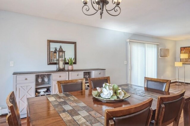 dining area with a chandelier and wood finished floors