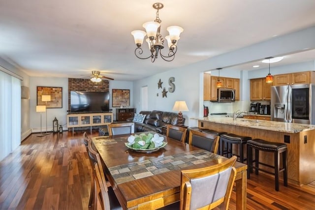 dining space with dark wood finished floors, ceiling fan with notable chandelier, and baseboards