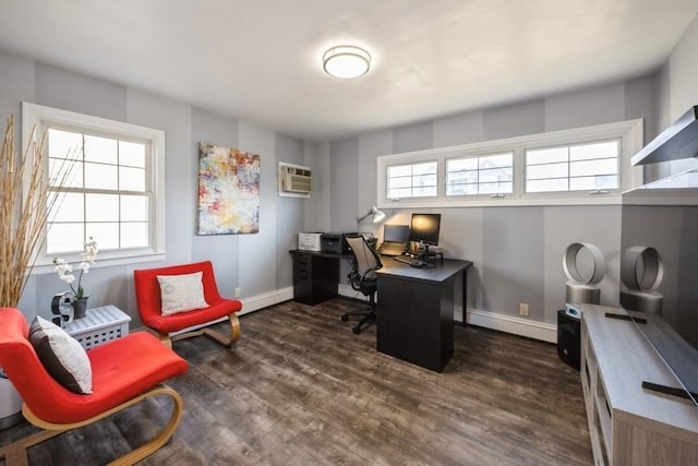 office space with a wall unit AC, a healthy amount of sunlight, baseboards, and dark wood-style flooring