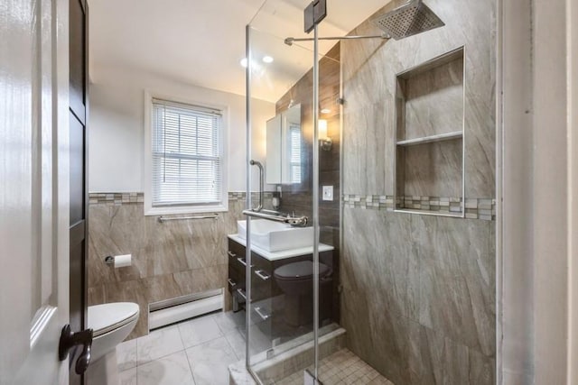 full bathroom with toilet, tile walls, a shower stall, baseboard heating, and vanity