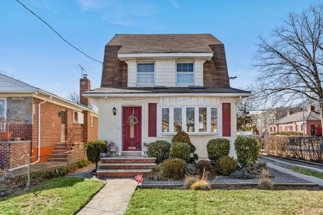 dutch colonial with fence and a gambrel roof