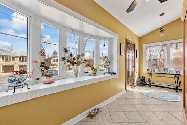 sunroom with vaulted ceiling, baseboard heating, and ceiling fan