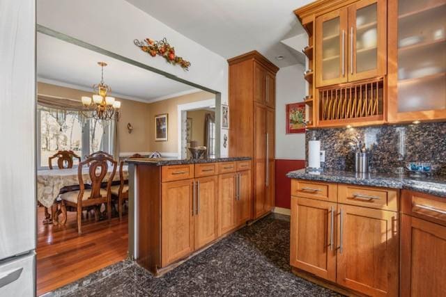 kitchen featuring pendant lighting, a peninsula, granite finish floor, and brown cabinets