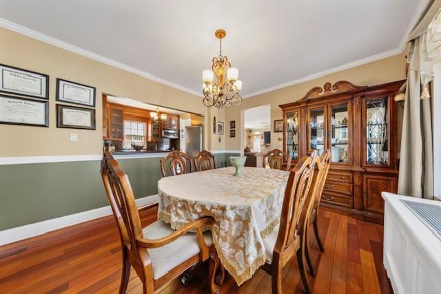 dining area featuring baseboards, ornamental molding, dark wood finished floors, and a notable chandelier