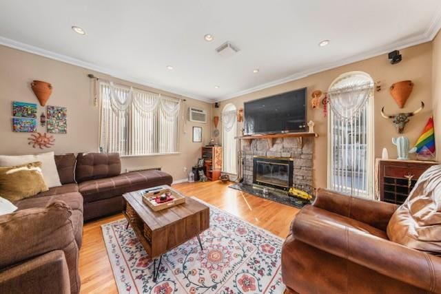 living area featuring light wood-style floors, a healthy amount of sunlight, and crown molding