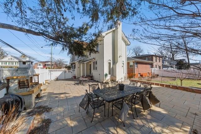 view of patio with a fenced backyard, a fireplace, and outdoor dining area