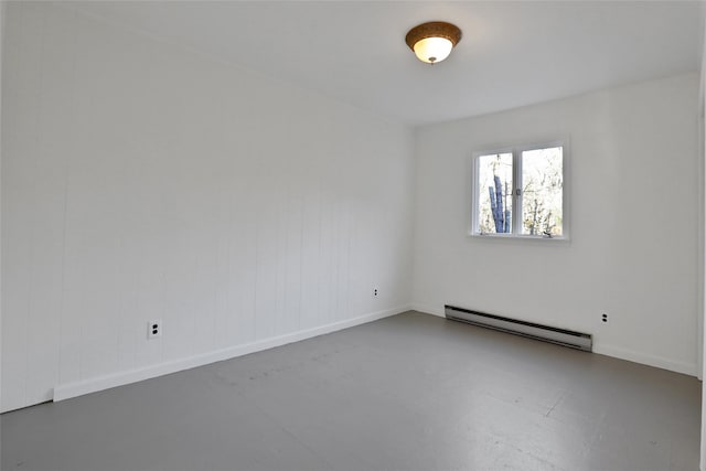 spare room with concrete floors, baseboard heating, and baseboards