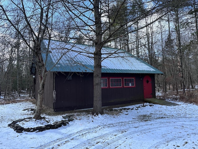 snow covered structure with a garage