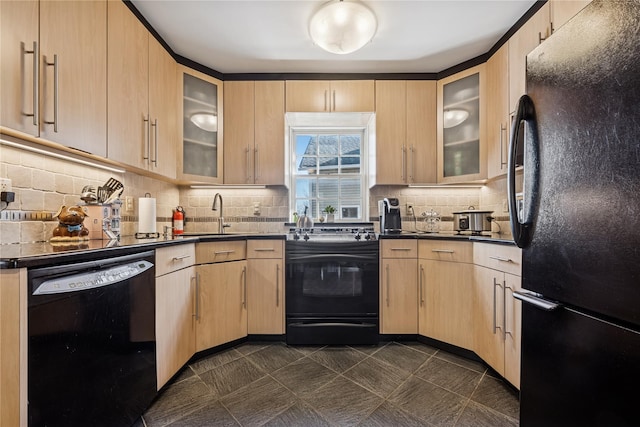 kitchen with black appliances, light brown cabinets, a sink, dark countertops, and tasteful backsplash