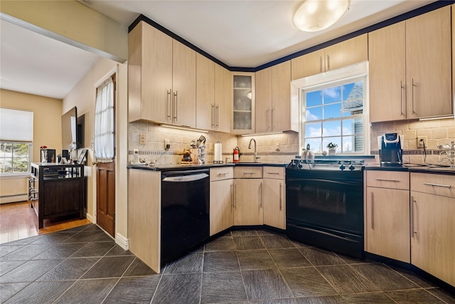 kitchen with dark countertops, backsplash, light brown cabinets, and black appliances