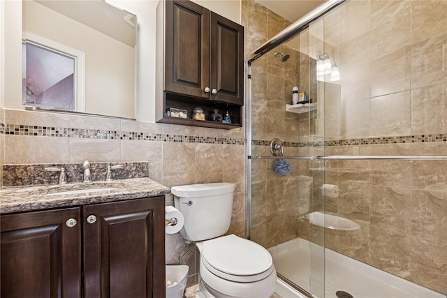 bathroom featuring a stall shower, toilet, tile walls, and vanity