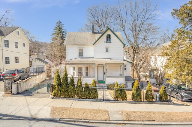 view of front of property featuring a fenced front yard, a gate, and a porch