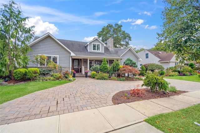 view of front of property featuring stone siding, a chimney, and a front lawn